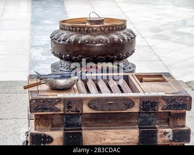 Bruciatore di incenso e scatola per le monete all'ingresso del Santuario di Shinto. Foto Stock