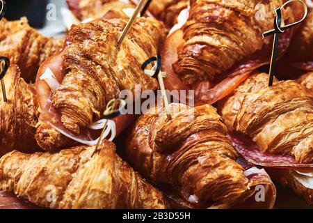 Una serie di croissant e panini con varie rifilature, formaggio, prosciutto di Parma, mozzarella e pomodori. Fast Food Patern. Foto Stock