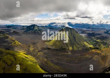 Veduta aerea, montagne coperte di muschio, ghiacciaio Myrdalsjoekull nella parte posteriore, altopiani islandesi, Islanda Foto Stock