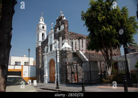 18th secolo chiesa dipinta di bianco a Città del Messico tra le strade a due colori che adornano con le facciate rustiche giallo-bianco Foto Stock