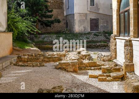 Antiche rovine romane in un piccolo cortile vicino ad una casa italiana nella città di Brindisi Italia, parte della Puglia. Foto Stock