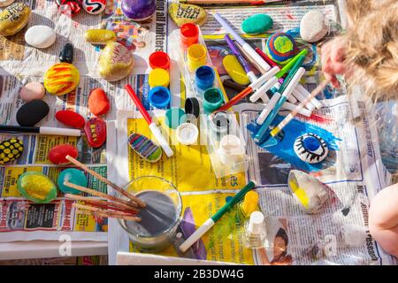 Bambino pittura rocce con acquerelli sul giornale, luminoso con un sacco di colori. Foto Stock