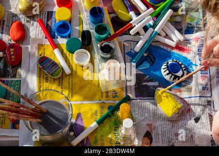 Bambino pittura rocce con acquerelli sul giornale, luminoso con un sacco di colori. Foto Stock