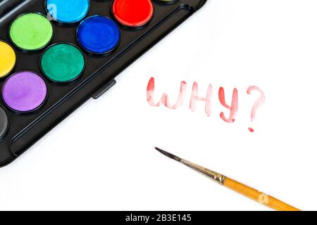 Scritto a mano PERCHÉ il testo con pennello e vernici acquerello su sfondo bianco. Scatola di vernici ad acqua con pennello per disegnare Foto Stock