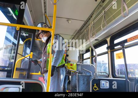 Larry Bowles, un addetto alla manutenzione della King County Metro, applica un disinfettante con un nebulizzatore chimico su un pullman della King County Atlantic base di Seattle il 4 marzo 2020. All'inizio della settimana, l'agenzia aveva aumentato la frequenza di pulizia della propria flotta di 1.600 autobus ad una procedura giornaliera in risposta al nuovo coronavirus. King County Metro ha ora implementato il metodo di utilizzo del disinfettante Virex II 256 con uno spruzzatore chimico per proteggere i passeggeri. Foto Stock