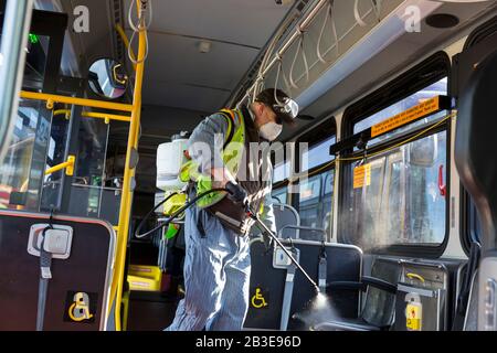 Larry Bowles, un addetto alla manutenzione della King County Metro, applica un disinfettante con un nebulizzatore chimico su un pullman della King County Atlantic base di Seattle il 4 marzo 2020. All'inizio della settimana, l'agenzia aveva aumentato la frequenza di pulizia della propria flotta di 1.600 autobus ad una procedura giornaliera in risposta al nuovo coronavirus. King County Metro ha ora implementato il metodo di utilizzo del disinfettante Virex II 256 con uno spruzzatore chimico per proteggere i passeggeri. Foto Stock