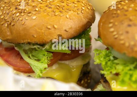 Due hamburger da vicino con patatine fritte, il ripieno di hamburger è chiaramente visibile Foto Stock