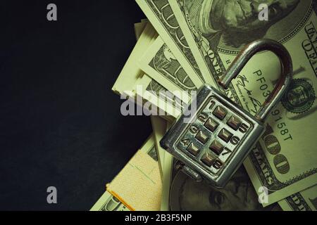 Lucchetto combinato su banconota da dollaro al mattino alla luce del sole. Vista dall'alto e spazio di copia. Sicurezza e segreto d'affari in stile vintage. Foto Stock
