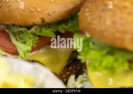 Due hamburger da vicino con patatine fritte, il ripieno di hamburger è chiaramente visibile Foto Stock