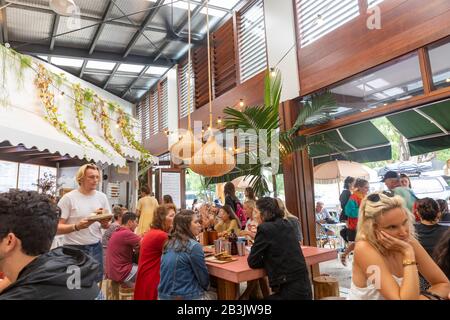 Byron Bay, giovani e amici che gustano la colazione al caffè Combi in una giornata di estati, Byron Bay, Australia Foto Stock