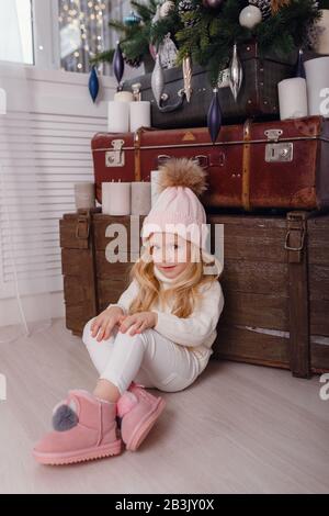 Piccola ragazza elegante che posa vicino all'albero di anno nuovo in previsione di Natale. Modaioli Modaioli Stylish scandinavo christamas decora Foto Stock