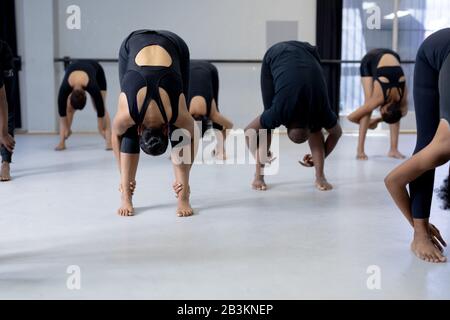 Ballerini moderni di razza mista che si allungano in uno studio Foto Stock