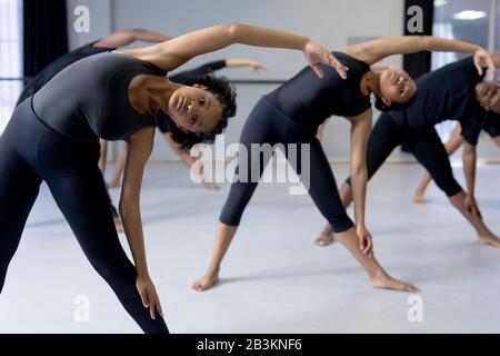 Ballerini moderni di razza mista che si allungano in uno studio Foto Stock