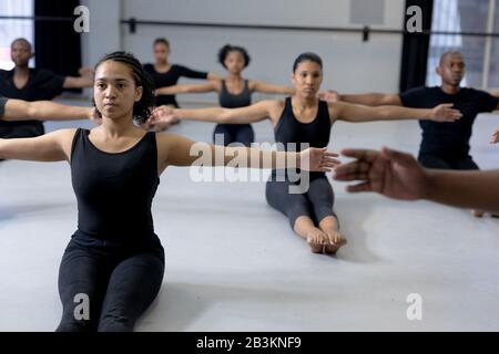 Ballerini moderni di razza mista che si allungano in uno studio Foto Stock