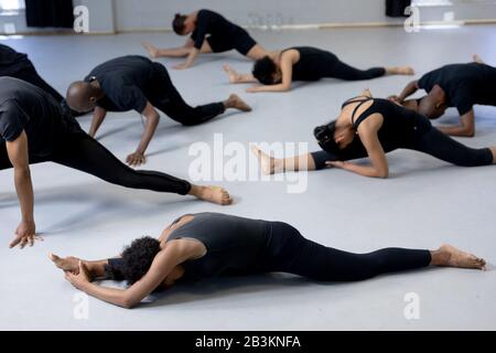 Ballerini moderni di razza mista che si allungano in uno studio Foto Stock