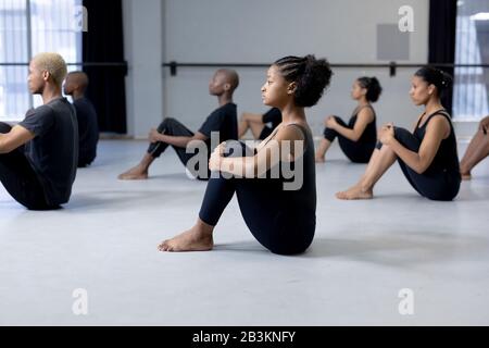 Ballerini moderni di razza mista che si allungano in uno studio Foto Stock