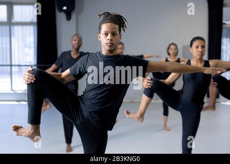 Ballerini moderni di razza mista che si allungano in uno studio Foto Stock