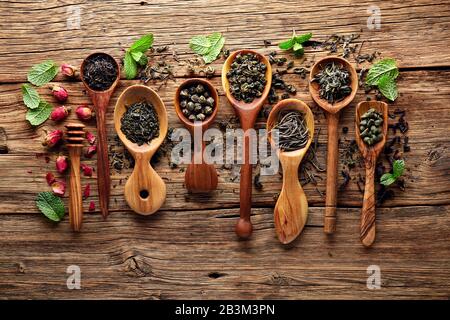 Collezione di foglie di tè su tavola di legno Foto Stock