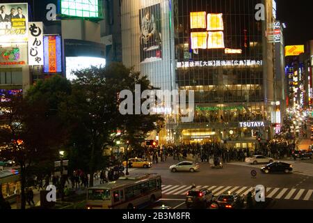 Fotografia notturna di un coronamento di pedoni che attraversa un incrocio a quattro vie zebra al passaggio Shibuya nel centro di Tokyo, Giappone Foto Stock