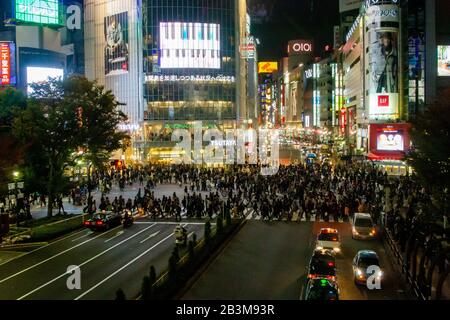 Fotografia notturna di un coronamento di pedoni che attraversa un incrocio a quattro vie zebra al passaggio Shibuya nel centro di Tokyo, Giappone Foto Stock