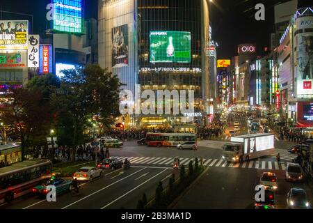 Fotografia notturna di un coronamento di pedoni che attraversa un incrocio a quattro vie zebra al passaggio Shibuya nel centro di Tokyo, Giappone Foto Stock