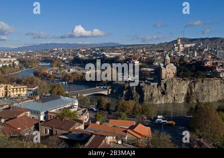 Centro storico di Tbilisi: Chiesa di Metekhi con Cattedrale di Sameba sullo sfondo. Il phoro contiene tetti di vecchie case e il fiume Kura nel for Foto Stock