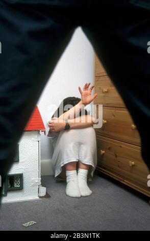 Il padre sta per colpire la figlia che cowering nella sua camera da letto, Vittima di abuso del bambino. Posto dal modello Foto Stock