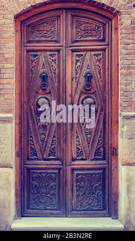 Una porta ornately intagliata e decorata ad una proprietà residenziale nel vecchio quartiere di Granada, la Spagna Meridionale Foto Stock