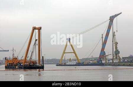 Rostock, Germania. 05th Mar, 2020. Nel porto marittimo la gru galleggiante "Baltic Lift" (l) del Baltic Taucher Rostock sta recuperando i bracci delle due nuove gru portuali, che sono cadute nel bacino del porto durante il loro carico alla fine di gennaio. Sulla destra si trova la gru galleggiante molto più grande "Hebo Lift 9" da Rotterdam (Paesi Bassi), che sarà responsabile del recupero effettivo delle gru. Credito: Bernd Wüstneck/Dpa-Zentralbild/Dpa/Alamy Live News Foto Stock