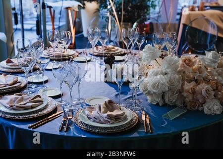 Bicchieri, forchette, coltelli, piatti su un tavolo nel ristorante servito per cena. Bicchieri Vuoti. Tavolo, ristorante che serve, interni. Foto Stock