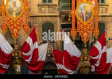 Valleta Malta 9 febbraio 2020: Bandiere e bandiere luminose fuori dalla Chiesa di San Paolo Valetta parte della festa del naufragio di San Paolo Foto Stock