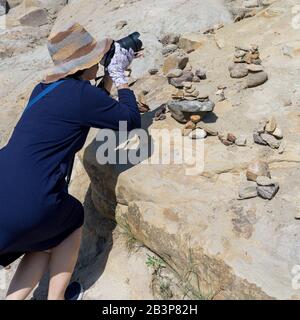 Donna che scatta fotografie di rocce di hoodoo, Drumheller, Red Deer River, Alberta, Canada Foto Stock