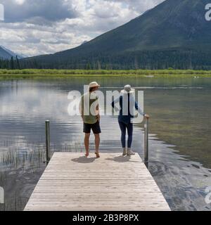 Coppia in piedi su un molo, Vermilion Lakes, Banff National Park, Alberta, Canada Foto Stock