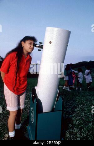 Austin Texas USA (non datata): Ragazza di quinto grado che guarda la luna attraverso il telescopio durante il viaggio di classe campo per studiare l'astronomia. SIGNOR ©Bob Daemmrich Foto Stock