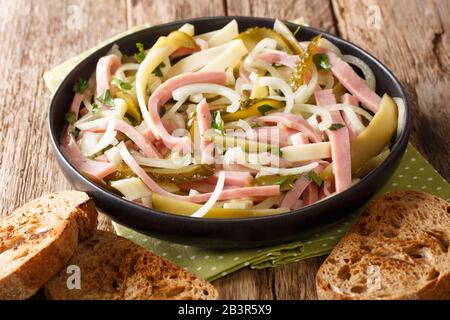 Servizio di insalata svizzera di salsiccia primo piano in un piatto sul tavolo. Orizzontale Foto Stock