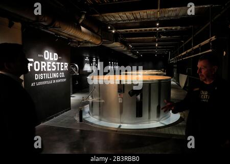 Guida turistica che presenta il processo di fermentazione del whisky ai visitatori Dal fermentatore di metallo durante il tour di Old Forester Distilling Co.Louisville.Kentucky.USA Foto Stock