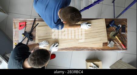 Uomini falegnami lucidare tela di superficie di legno sul tavolo Foto Stock