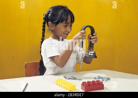 Austin, Texas USA: Ragazza ispanica che sperimenta con i magneti. SIGNOR ©Bob Daemmrich Foto Stock