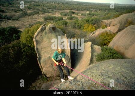 Enchanted Rock state Park, Texas USA: La bambina di nove anni inizia a scendere dalla scogliera durante una lezione di arrampicata. ©Bob Daemmrich Foto Stock