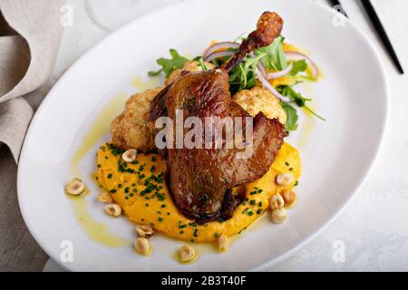 Zampa di pollo arrosto con cavolfiore e purea di zucca butternut Foto Stock