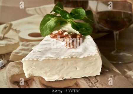 Il formaggio si stagia sul vecchio tavolo di legno in cucina. Prodotto caseario. Mangiare sano e lifestyle. Foto Stock