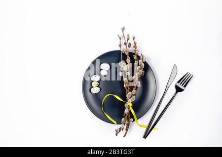 Piatti neri con biscotti di pan di zenzero, rami salici e decorazioni pasquali su sfondo grigio in cemento. Concetto di vacanza primaverile. Copia spazio, Easte Foto Stock