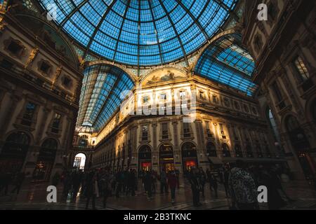 Milano, ITALIA - 5 febbraio 2016: Incrocio del centro commerciale porticato Galleria Vittorio Emanuele II con persone e famosi negozi di moda come Prada, in Dome Foto Stock