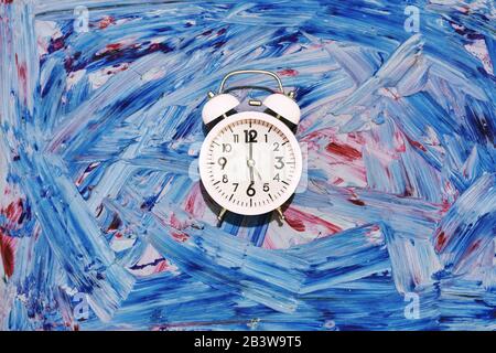 ore 06:00 orologio. Mattina presto. È ora di svegliarsi. È il momento di andare a scuola o al lavoro. Una sveglia rosa vintage sul classico retro alla moda di colore blu Foto Stock