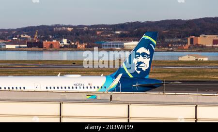 Alaska Airlines coda fin visto mentre a un cancello, al Reagan Washington National Airport durante il giorno. Foto Stock