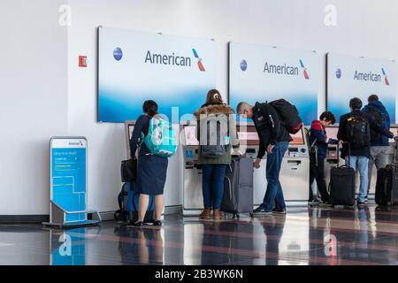 Persone che hanno visto utilizzare i chioschi di check-in self-service per American Airlines all'interno dell'aeroporto nazionale Ronald Reagan di Washington. Foto Stock