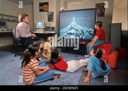 Texas USA, marzo 1998: Gli studenti della scuola media guardano un feed dal vivo da un mestiere esplorativo sottomarino durante una lezione di video scienza. ©Bob Daemmrich Foto Stock