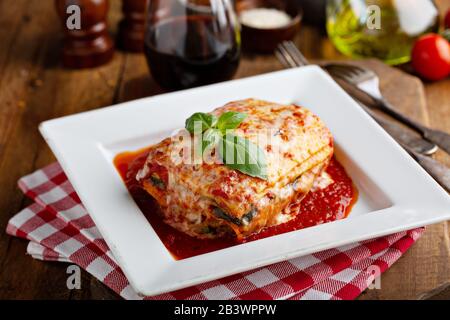 Classico pezzo di lasagna su un piatto con foglia di basilico in alto Foto Stock