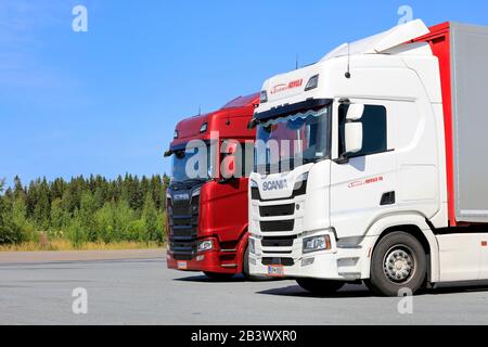 I veicoli semi-rimorchi rossi Scania S580 e bianchi Scania R500 parcheggiati su una sosta per camion in una giornata di sole d'estate. Jalasjarvi, Finlandia. 10 Agosto 2019. Foto Stock