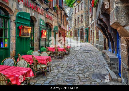 Dinan, Francia - 10 luglio 2017: Tipica strada acciottolata con caffè all'aperto nella storica città vecchia di Dinan. Dinan è un popolare turista destina Foto Stock